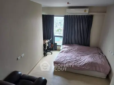 Cozy bedroom with city view, featuring a comfortable bed and study area, perfect for urban living.