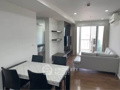 Modern living room with sleek furniture and balcony access in a stylish apartment.