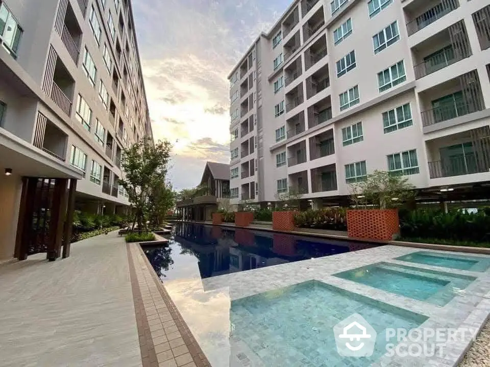 Modern apartment complex with pool and garden view at sunset