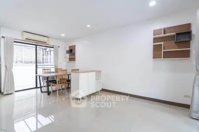 Spacious modern living room with dining area and stylish shelving, perfect for contemporary living.