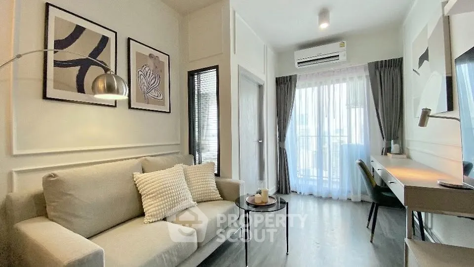 Modern living room with stylish decor and natural light, featuring a cozy sofa and work desk.