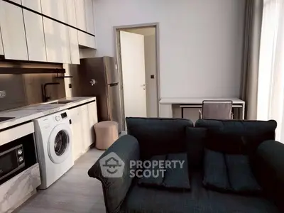 Modern studio apartment with sleek kitchen and cozy living area