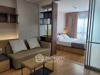 Modern studio apartment with cozy living area and bedroom, featuring stylish furniture and natural light.
