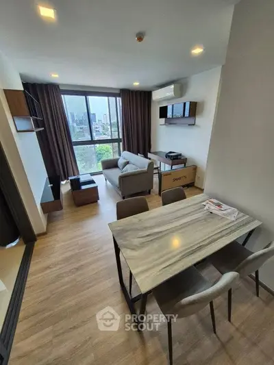 Modern living room with large window and stylish furniture in a high-rise apartment.