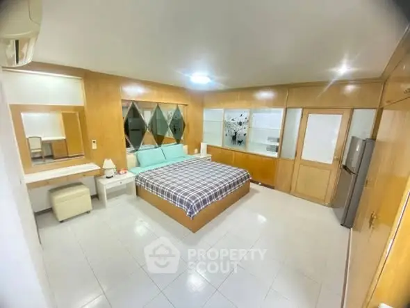 Spacious bedroom with modern decor and ample natural light, featuring a large bed and stylish furnishings.