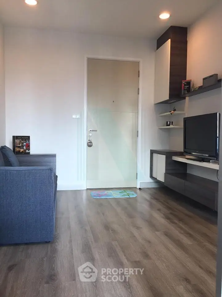Modern living room with sleek furniture and wooden flooring, perfect for cozy urban living.