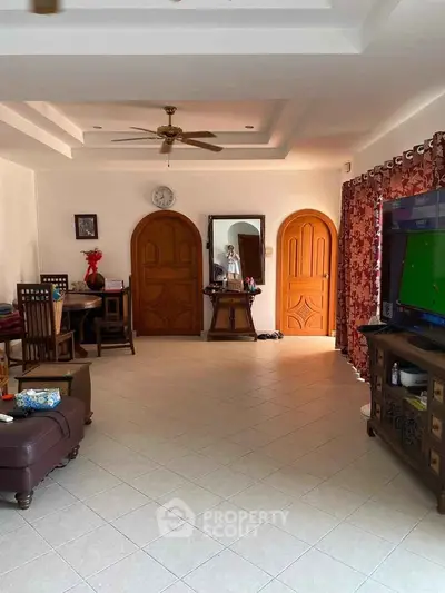 Spacious living room with elegant wooden doors and modern decor