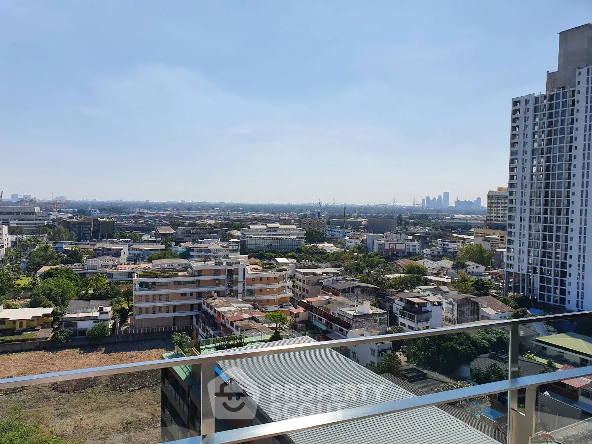 Stunning cityscape view from high-rise balcony showcasing urban skyline and residential buildings.