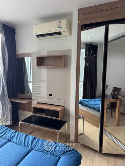 Modern bedroom with mirrored wardrobe and air conditioning unit