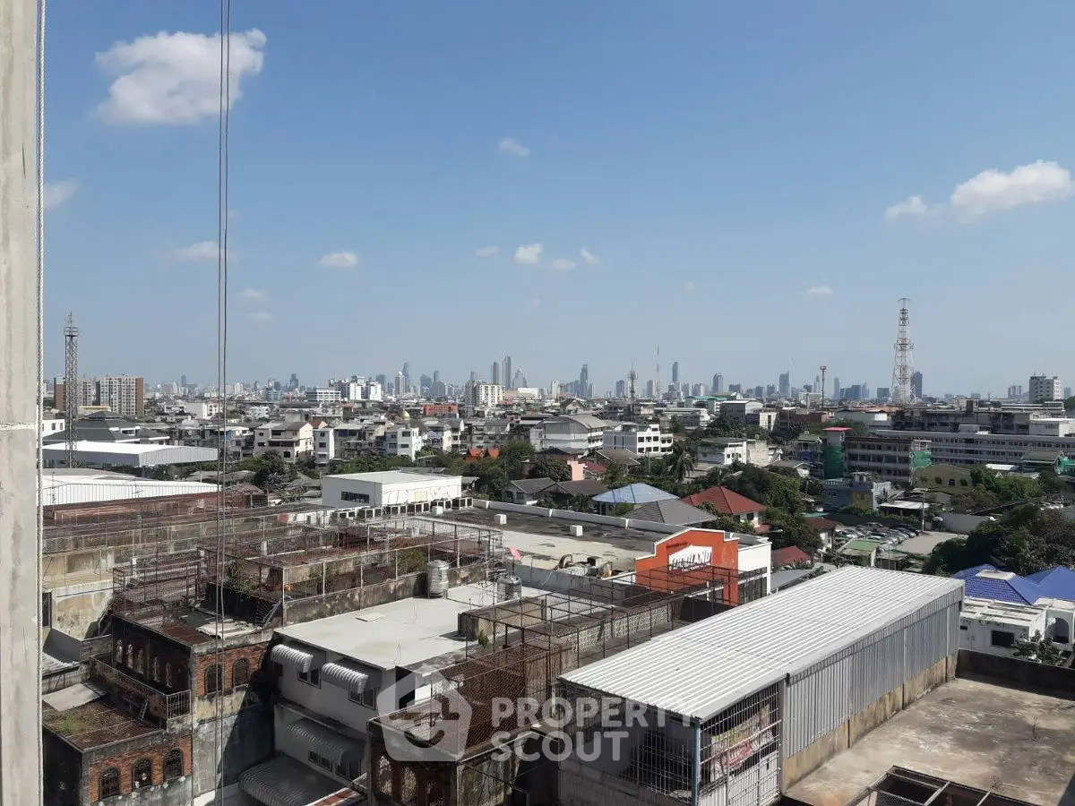 Stunning cityscape view from a high-rise building, showcasing urban skyline and clear blue sky.