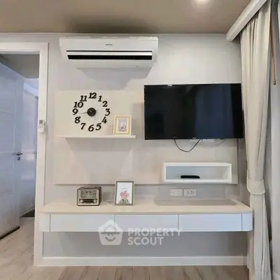 Modern living room with wall-mounted TV and air conditioner, stylish clock, and sleek decor.