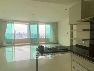 Spacious modern apartment with open kitchen and stunning city view from large windows.
