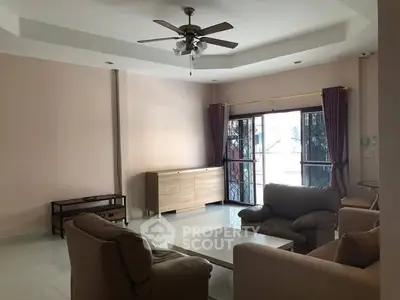 Spacious living room with modern furniture and ceiling fan, perfect for relaxation.