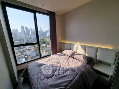 Modern bedroom with city view, featuring a cozy bed and large window overlooking skyline.