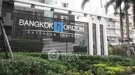 Modern building entrance with sleek design and lush greenery at Bangkok Horizon Ratchada.