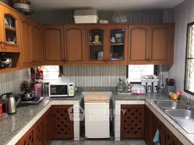 Charming kitchen with warm wooden cabinetry and modern appliances, featuring ample counter space and a cozy atmosphere.