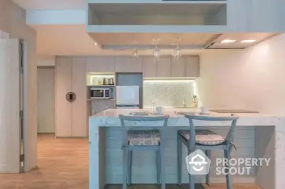 Modern kitchen with sleek design, featuring a breakfast bar and stylish lighting.