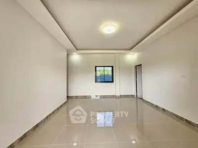 Spacious empty room with glossy tiled floor and modern ceiling light