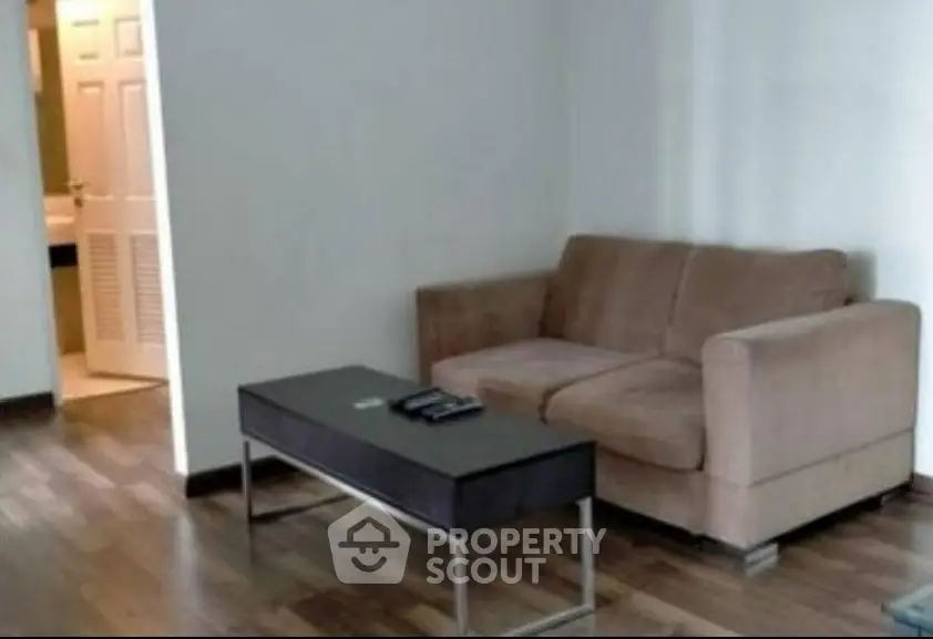 Cozy living room with modern sofa and sleek coffee table on wooden flooring.