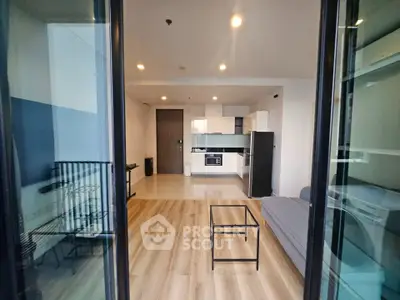 Modern open-plan living room with sleek kitchen and stylish decor in a contemporary apartment.