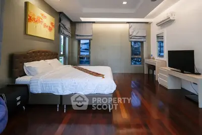 Spacious bedroom with elegant wooden flooring and modern decor