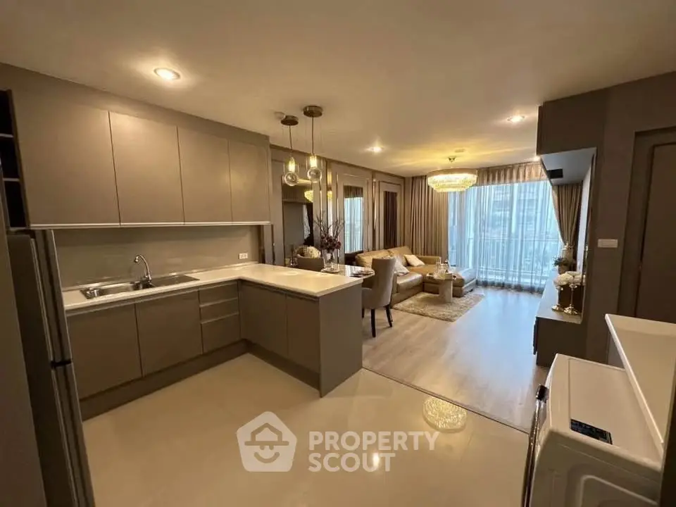 Modern open-layout kitchen and living room with elegant lighting and neutral tones.
