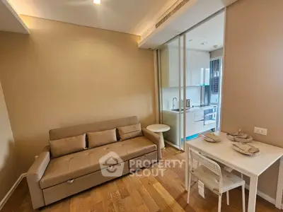 Modern living room with cozy sofa and compact kitchen in open layout apartment.
