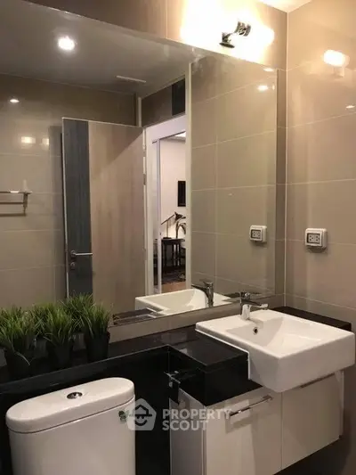 Modern bathroom with sleek fixtures and elegant design, featuring a stylish sink and mirror.