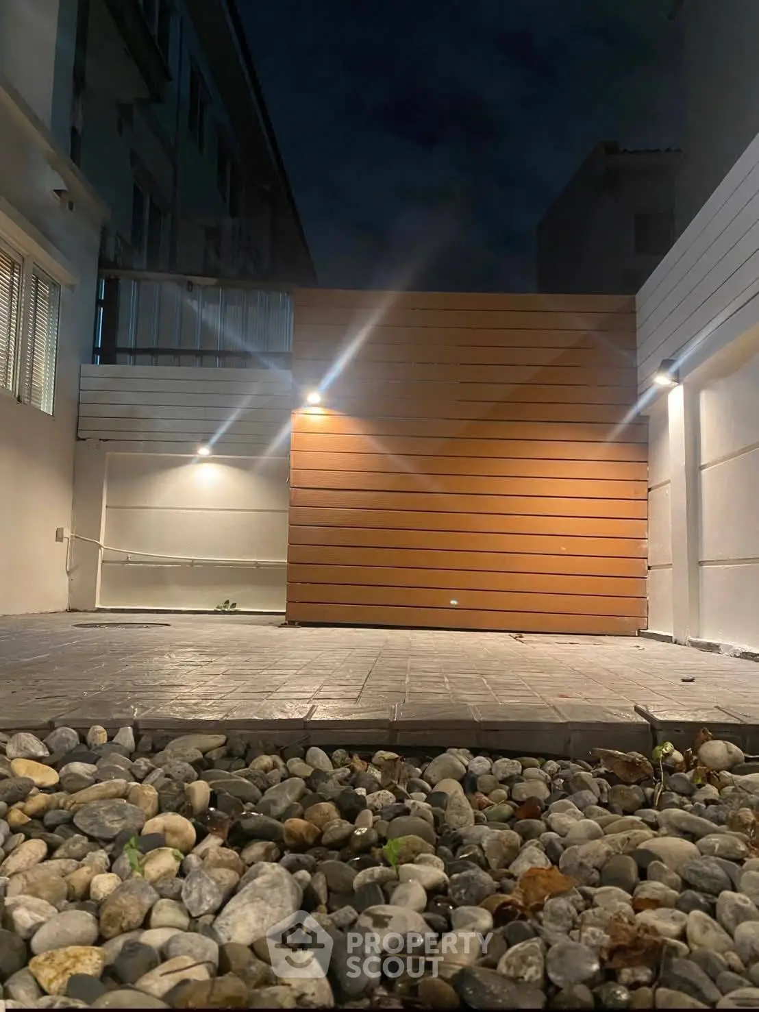 Modern outdoor patio with stylish lighting and stone flooring, perfect for evening relaxation.