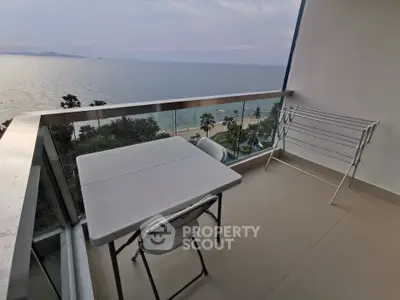 Stunning ocean view from a spacious balcony with seating area, perfect for relaxation and enjoying sunsets.
