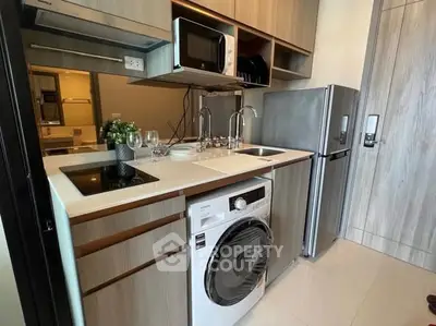 Modern compact kitchen with integrated appliances and sleek cabinetry