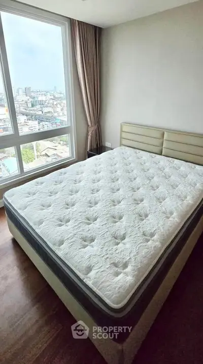 Spacious bedroom with city view and large window, perfect for urban living.