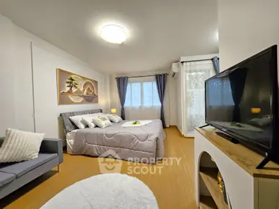 Spacious bedroom with modern decor and natural light, featuring a cozy bed and stylish furnishings.