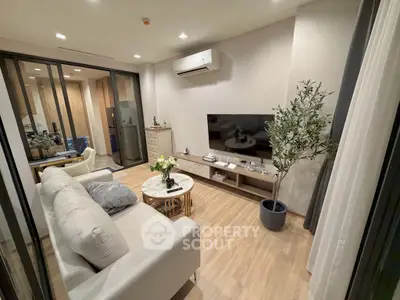 Modern living room with sleek design, featuring a cozy sofa, flat-screen TV, and elegant decor.