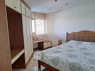 Spacious bedroom with elegant wooden furniture and natural light