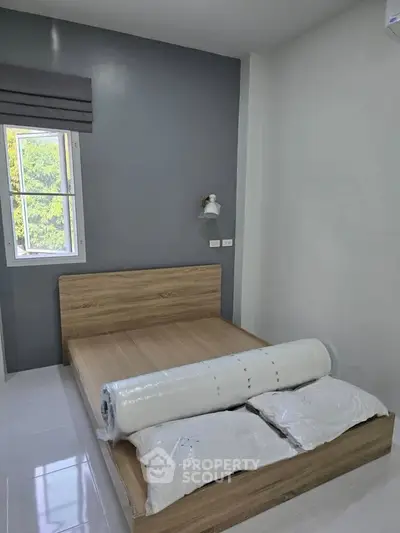 Modern bedroom with wooden bed frame and natural light from window