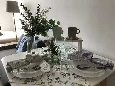 Charming dining setup in cozy living space with elegant tableware and floral decor.