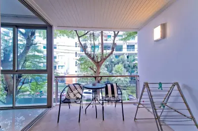 Spacious balcony with seating and lush garden view in modern apartment