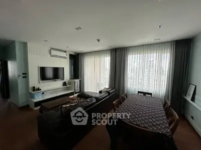 Spacious living room with modern decor and large windows offering city views.