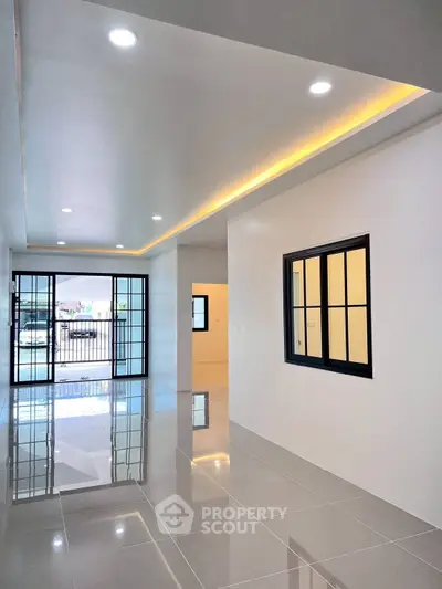 Spacious modern living room with sleek tile flooring and large windows for natural light.