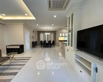 Spacious open-plan living and dining area with modern furnishings and elegant lighting.