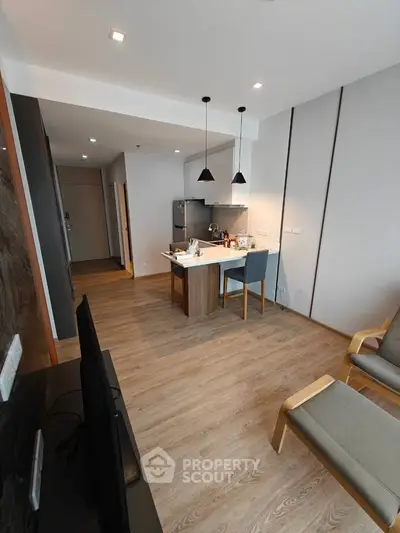 Modern open-plan living room with sleek kitchen and stylish furnishings.