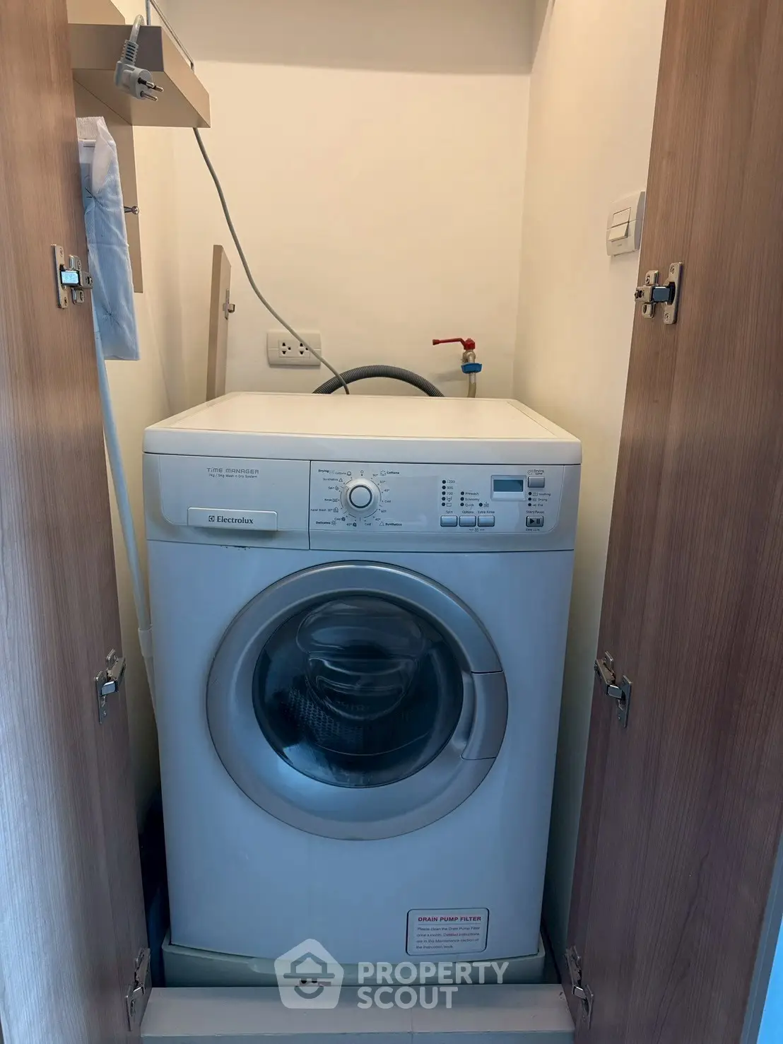 Compact laundry space with modern washing machine in a cozy utility closet.