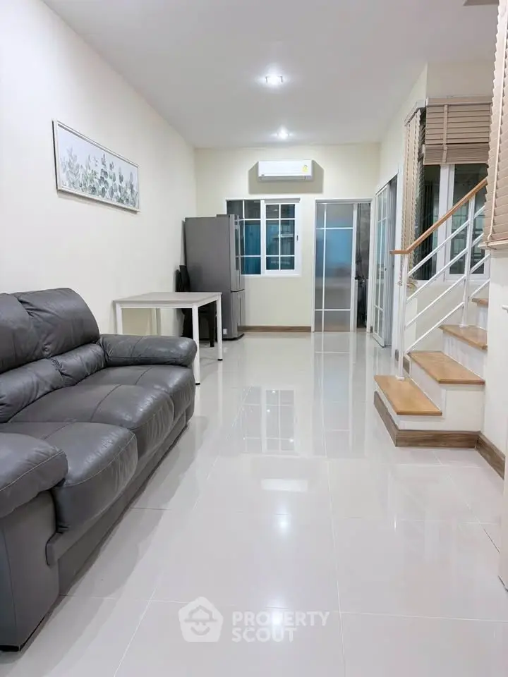 Spacious living room with modern leather sofa and sleek tile flooring