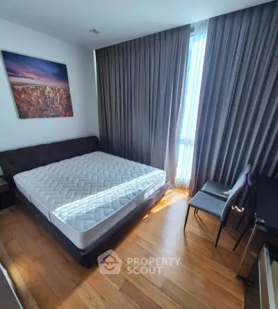 Modern bedroom with large window, wooden flooring, and stylish decor