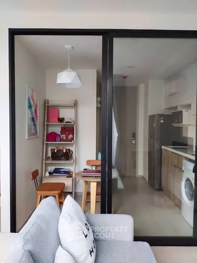 Chic modern apartment with a seamless open layout connecting a cozy living area to a well-equipped kitchen, featuring sleek appliances and ample natural light.