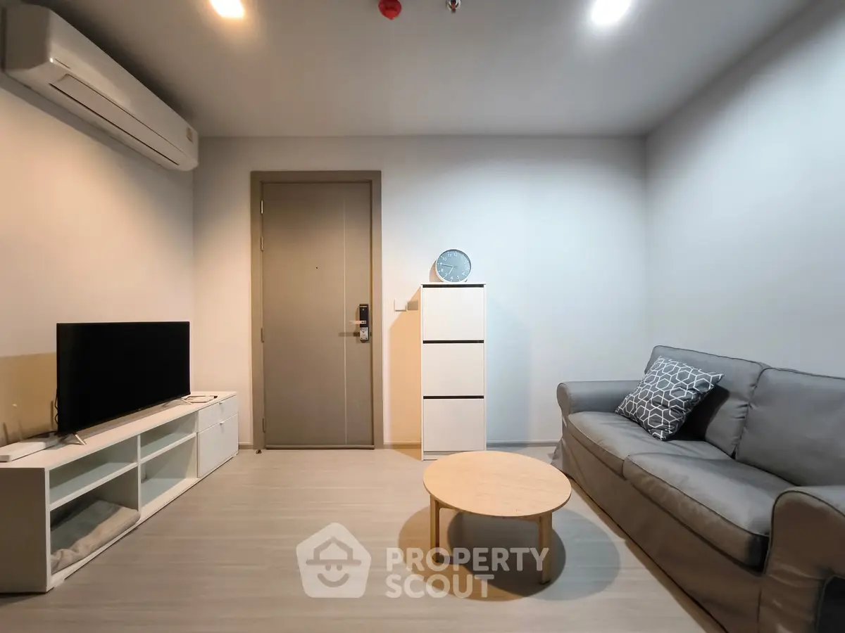 Modern living room with sleek furniture and minimalist design, featuring a cozy sofa and stylish decor.