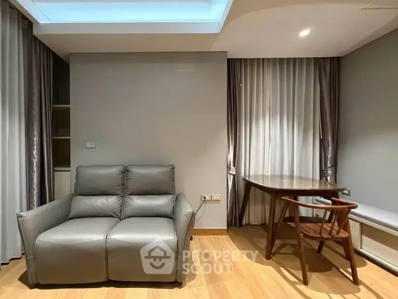 Modern living room with sleek leather sofa and elegant wooden table, perfect for stylish urban living.