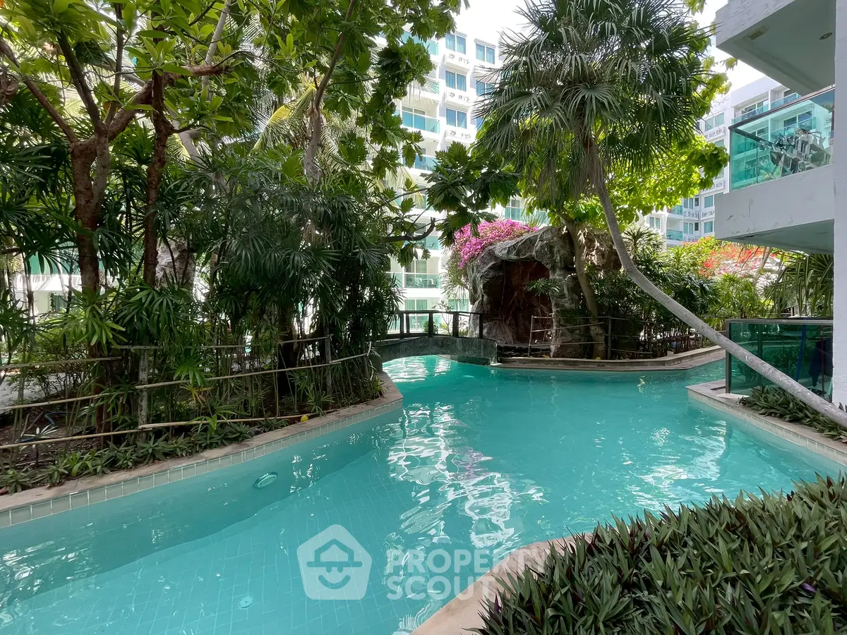 Luxurious tropical pool surrounded by lush greenery in a modern residential complex.