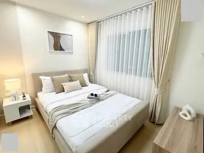 Elegant bedroom with modern decor and natural light, featuring a cozy bed and stylish furnishings.